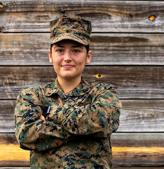 Military woman stands with arms crossed