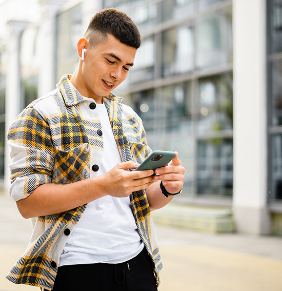 Man with headphones looks at phone