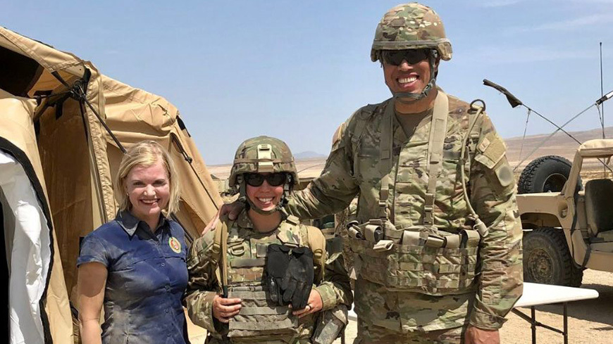 Three military members smile together