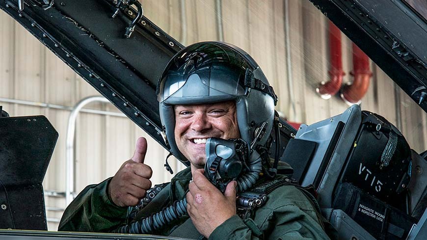 Pilot in plane smiling with thumbs up