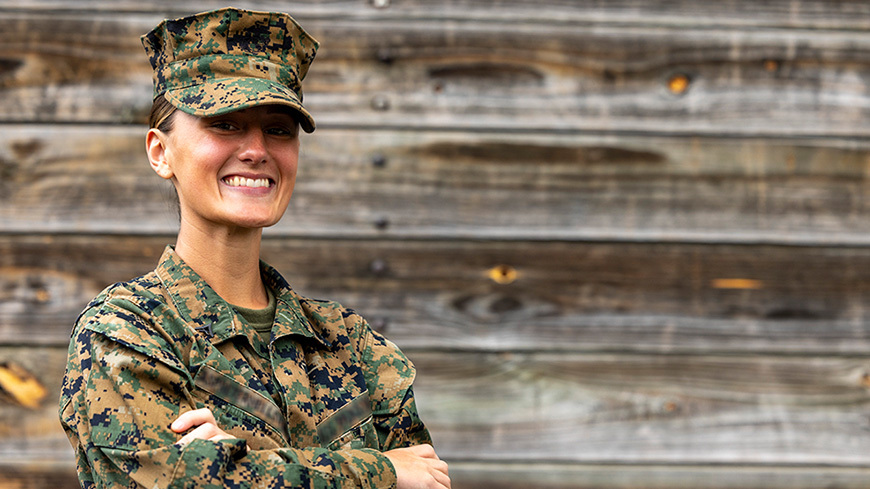 Military woman stands with arms crossed